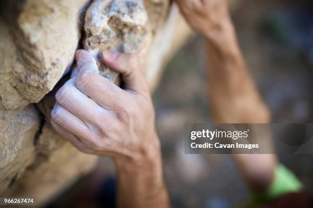 Premium Photo  A man climbing a boulder with a rock climbing outfit on his  hands.