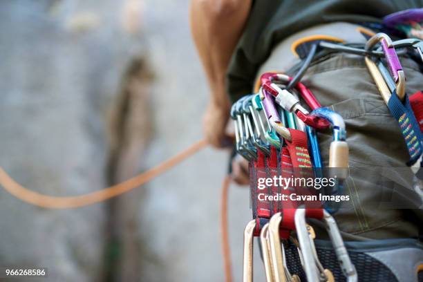 midsection of man with climbing equipment - artículo de montañismo fotografías e imágenes de stock