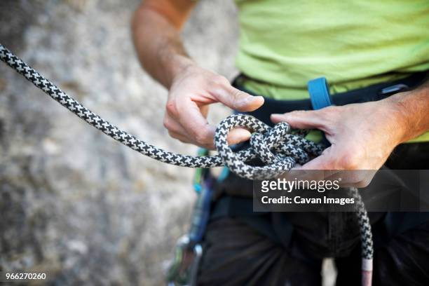 mid section of man adjusting climbing rope - 爬山繩 個照片及圖片檔