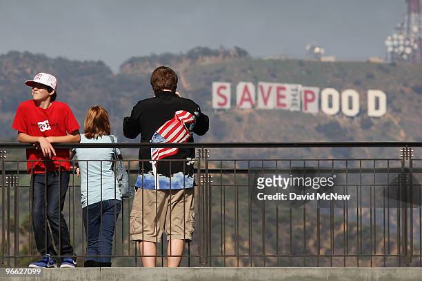 Visitors to the Hollywood and Highland complex take in the sights as activists continue covering the iconic 450-foot-long Hollywood sign with banners...