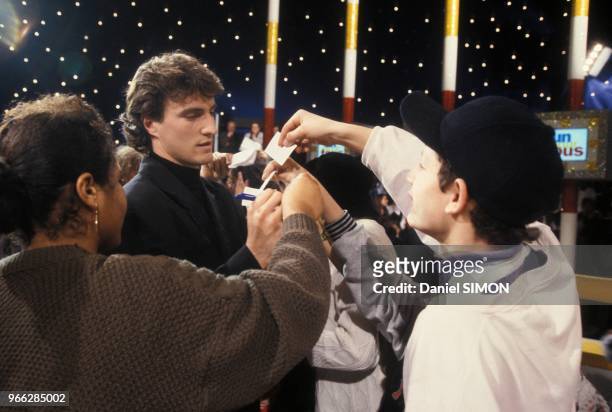 Le footballeur David Ginola signe des autographes sur le plateau de l'emission de television Un pour Tous special Noel le 15 decembre 1993 a Paris,...
