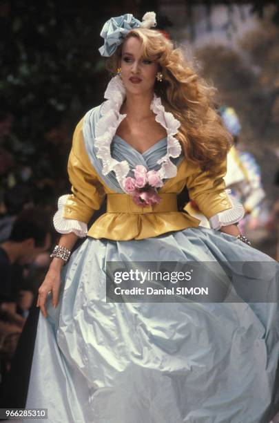 Jerry Hall presents a model by Chanel Haute Couture Spring Summer 1985 show on January 29, 1985 in Paris, France.