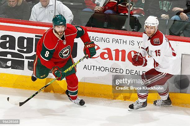 Brent Burns of the Minnesota Wild and Matthew Lombardi of the Phoenix Coyotes skate to the puck during the game at the Xcel Energy Center on February...