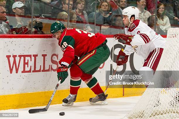 Robbie Earl of the Minnesota Wild and Keith Yandle of the Phoenix Coyotes fight for the puck during the game at the Xcel Energy Center on February...