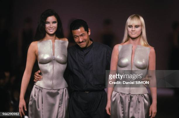 Le styliste japonais Issey Miyake avec deux mannequins au defile de mode Pret-a-Porter Automne-Hiver le 21 mars 1985 a Paris, France.