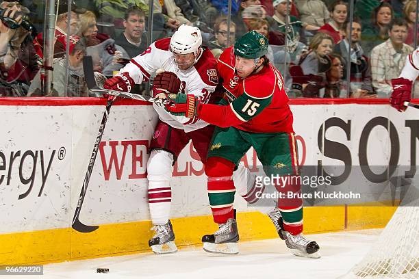 Andrew Brunette of the Minnesota Wild battles for control of the puck with Vernon Fiddler of the Phoenix Coyotes during the game at the Xcel Energy...