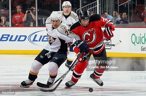 Jordin Tootoo of the Nashville Predators battles for a loose puck against Matthew Corrente of the New Jersey Devils at the Prudential Center on...