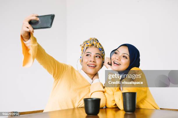 jonge vrouwen nemen van selfies - hijab fashion stockfoto's en -beelden