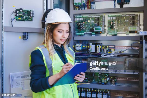 female stationary engineer take notes at energy control room - distribution board stock pictures, royalty-free photos & images