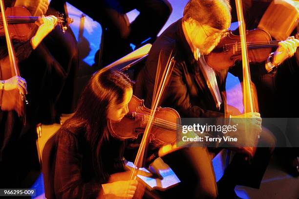 violinists in symphony orchestra, elevated view (blurred motion) - orchester stock-fotos und bilder