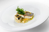 Fish dish slices of sea bass fillets on mashed vegetables