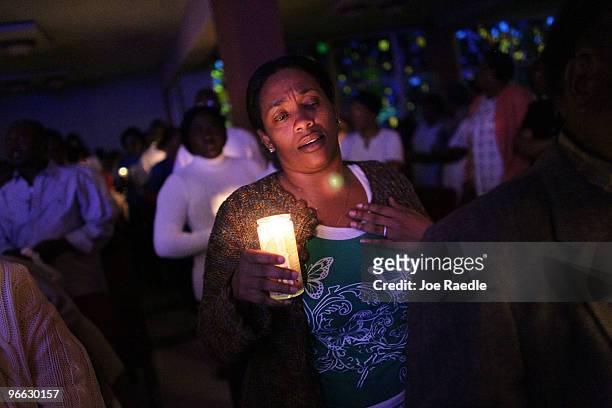 People of Haitian descent hold candles during a prayer vigil at the Notre Dame d'Haiti Catholic church as they mark the one month anniversary of the...