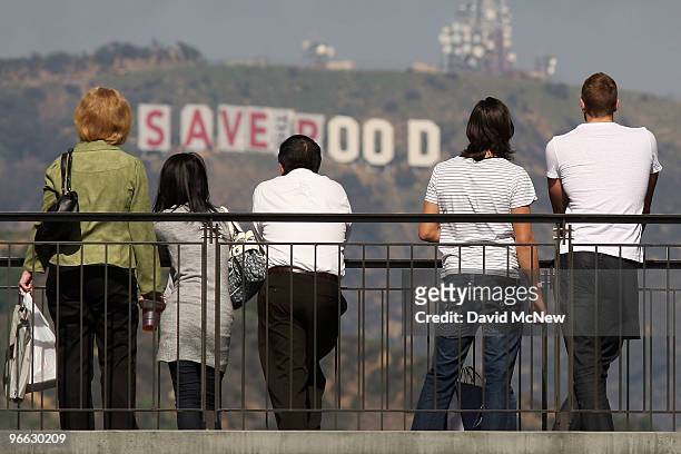 Visitors to the Hollywood and Highland complex take in the view as activists continue covering the iconic 450-foot-long Hollywood sign with banners...