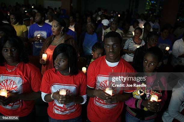 People of Haitian descent hold candles during a prayer vigil at the Notre Dame d'Haiti Catholic church as they mark the one month anniversary of the...