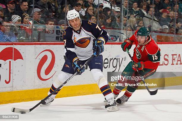 Pavel Kubina of the Atlanta Thrashers handles the puck with Andrew Brunette of the Minnesota Wild defending during the game at the Xcel Energy Center...