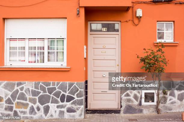 puerta de entrada a una casa de fachada naranja - fachada stockfoto's en -beelden