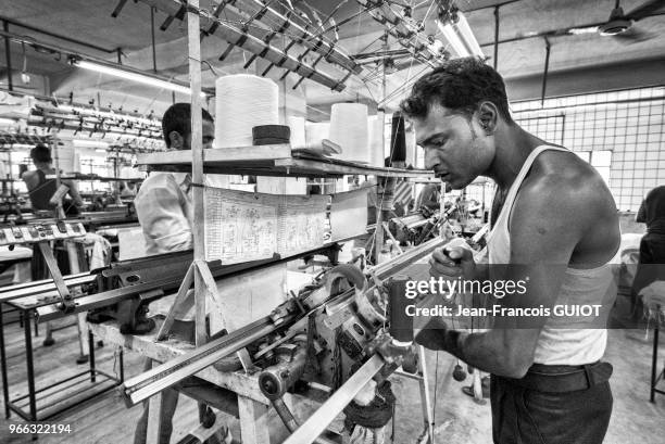 Tissage des parties d'un vêtement dans une usine de textile, 30 novembre 2016, banlieue de Savar, faubourg ouest de Dacca, Bangladesh.