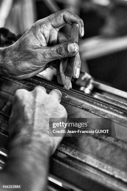 Nettoyage d'une tisseuse dans une usine de textile, 30 novembre 2016, banlieue de Savar, faubourg ouest de Dacca, Bangladesh.
