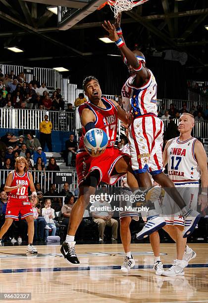 Personality Rick Fox shoots the ball over Harlem Globe Trotter Special K Daley during the 2010 NBA All-Star Celebrity Game presented by FINAL FANTASY...