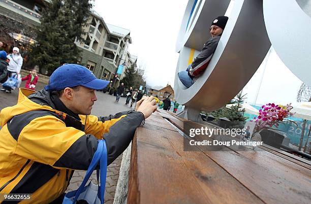 Dave Burke of San Francisco, California photographs an impromptu memorial to luger Nodar Kumaritashvili of Georgia that was placed under the Olympic...