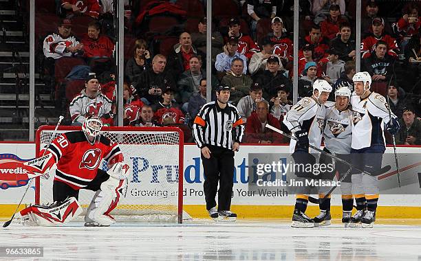 Jordin Tootoo of the Nashville Predators celebrates his goal with teammates Shea Weber and J.P. Dumont as Martin Brodeur of the New Jersey Devils...