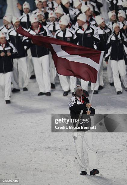 Martins Dukurs of Latvia carries the flag during the Opening Ceremony of the 2010 Vancouver Winter Olympics at BC Place on February 12, 2010 in...