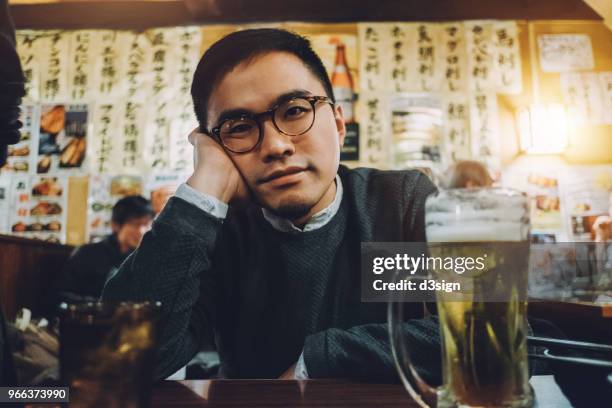 tired asian man drinking beer in a japanese style pub - izakaya stock pictures, royalty-free photos & images