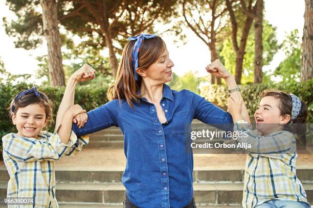 strong mom flexing her arms - girl power - womens issues stock pictures, royalty-free photos & images