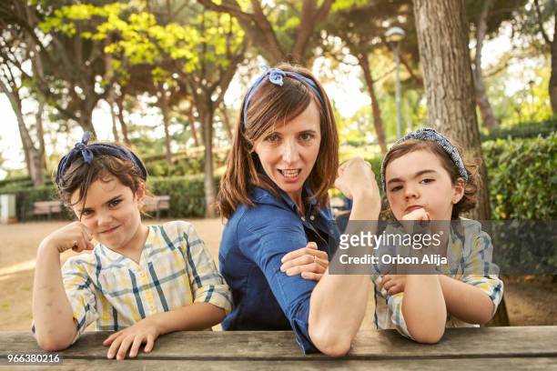 strong mom flexing her arms - girl power - strength stock pictures, royalty-free photos & images