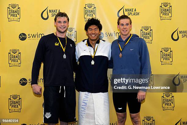 Masayuki Kishida , David Russell and Vytautas Janusaitis pose on the victory stand after the Men's 100 Meter Butterfly finals during day one of the...