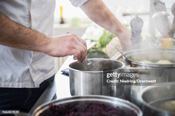 cook cooking food in pots on stove - saucepan stock pictures, royalty-free photos & images