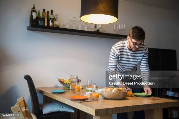 man lay a breakfast table, munich, germany - arranging stock pictures, royalty-free photos & images