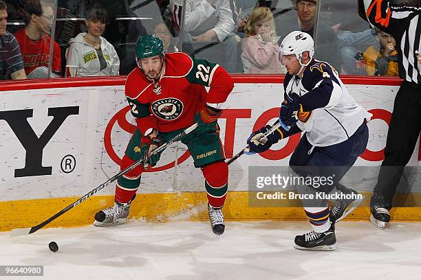 Cal Clutterbuck of the Minnesota Wild handles the puck with Zach Bogosian of the Atlanta Thrashers defending during the game at the Xcel Energy...