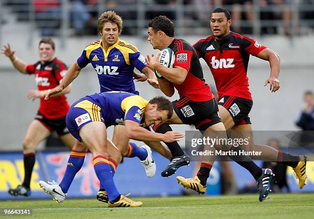 Dan Carter of the Crusaders is tackled by Israel Dagg of the Highlanders during the round one Super 14 match between the Crusaders and the...