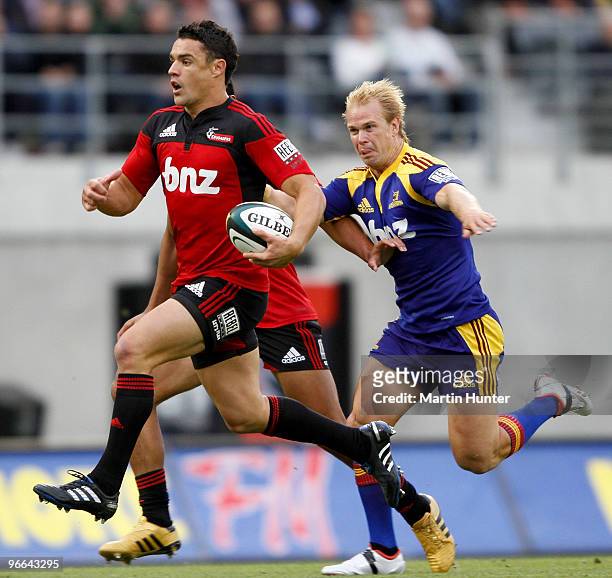 Dan Carter of the Crusaders breaks away from Jason Shoemark of the Highlanders during the round one Super 14 match between the Crusaders and the...