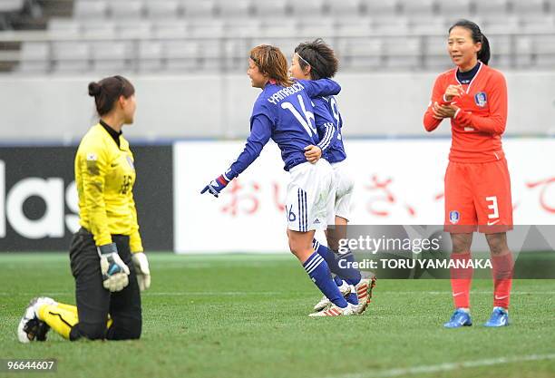 Japanese midfielder Mami Yamaguchi celebrates with her teammate Aya Miyama just after scoring a goal beside South Korean goalkeeper Kim Jung-Mi and...