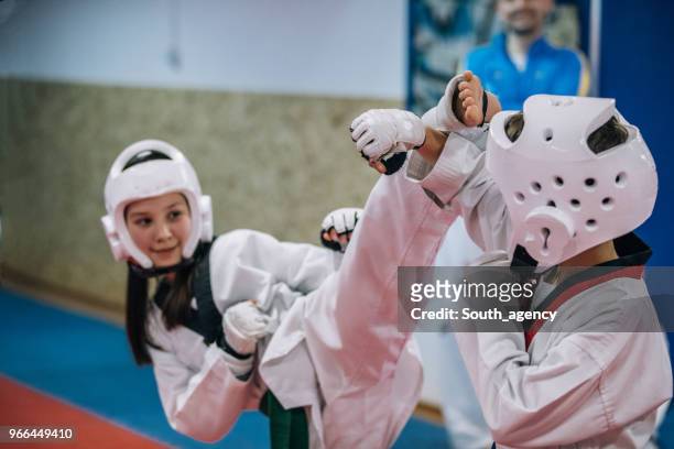 groupe d’enfants sur la formation de taekwondo en gym - arts martiaux photos et images de collection