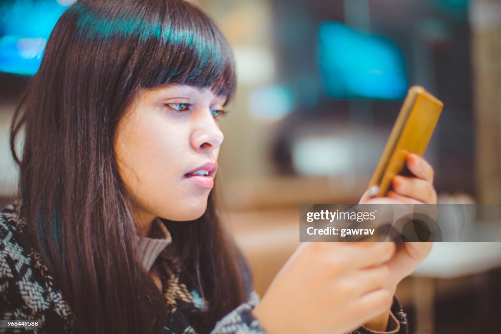 Junge Frau mit Smartphone ohne bücken Hals.