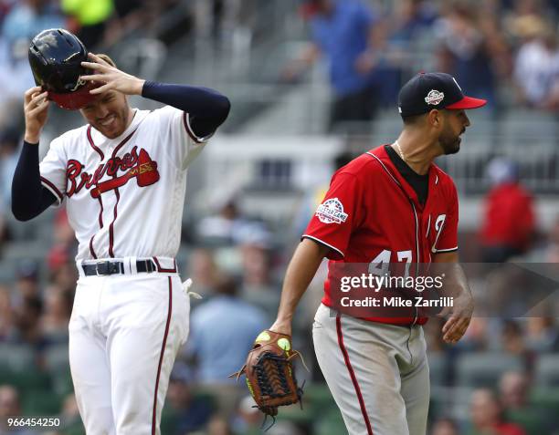 Pitcher Gio Gonzalez of the Washington Nationals jokes with first baseman Freddie Freeman of the Atlanta Braves during the game at SunTrust Park on...