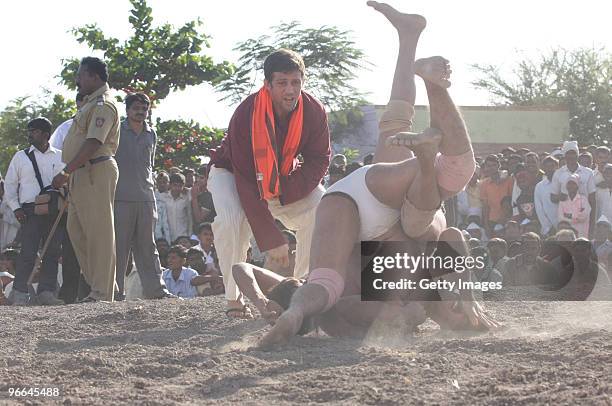 Celebrity Big Brother winner Alex Reid referees a mud wrestling match as he attends a khusti at an Akhada to watch local wrestling competitions held...