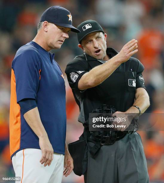 Manager AJ Hinch of the Houston Astros talks with home plate umpire Chris Guccione after he called Yuli Gurriel out for batter interference in the...