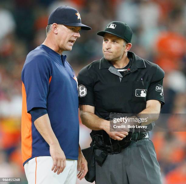 Manager AJ Hinch of the Houston Astros talks with home plate umpire Chris Guccione after he called Yuli Gurriel out for batter interference in the...