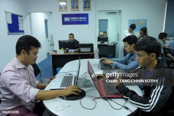 This picture taken on May 21, 2018 shows Cambodian online news outlet 'Fresh News' staff members working in their newsroom in Phnom Penh. - As...