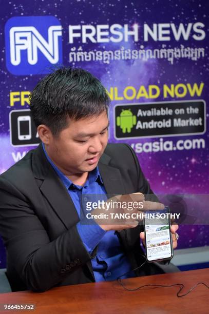 This picture taken on May 21, 2018 shows Cambodian online news outlet 'Fresh News' founder and Chief Executive Officer Lim Chea Vutha showing an app...