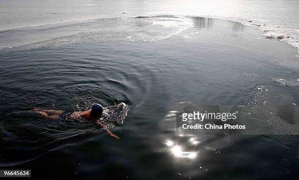 Chinese man swims in the icy Houhai Lake at a temperature around zero degrees centigrade on February 12, 2010 in Beijing, China. Houhai Lake is a...