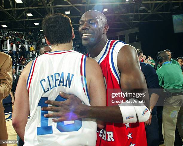 Player Terrell Owens hugs Dallas Mavericks owner Mark Cuban following the 2010 NBA All-Star Celebrity Game presented by FINAL FANTASY XIII on center...