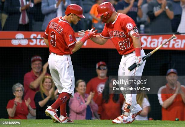 Ian Kinsler of the Los Angeles Angels of Anaheim is congratulated by Mike Trout for the sixth inning home run against the Texas Rangers at Angel...