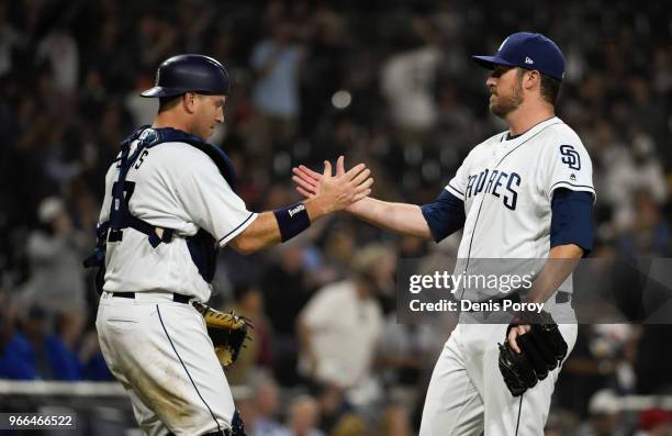 Phil Hughes of the San Diego Padres, is congratulated by A.J. Ellis after getting the final out during the ninth inning of a baseball game against...