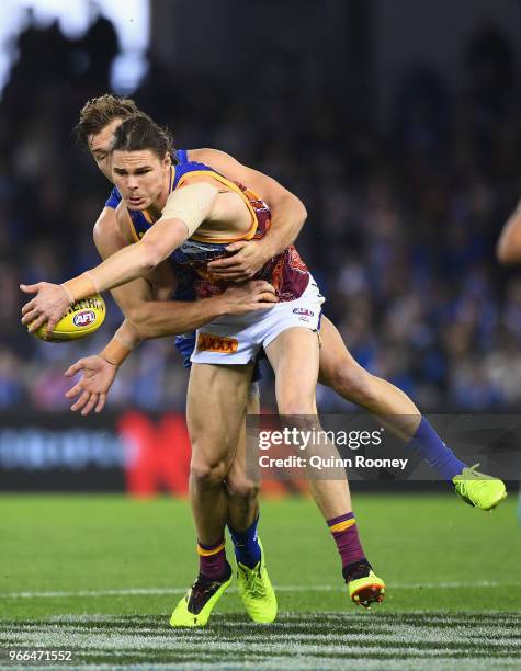 Eric Hipwood of the Lions is tackled by Shaun Higgins of the Kangaroos during the round 11 AFL match between the North Melbourne Kangaroos and the...