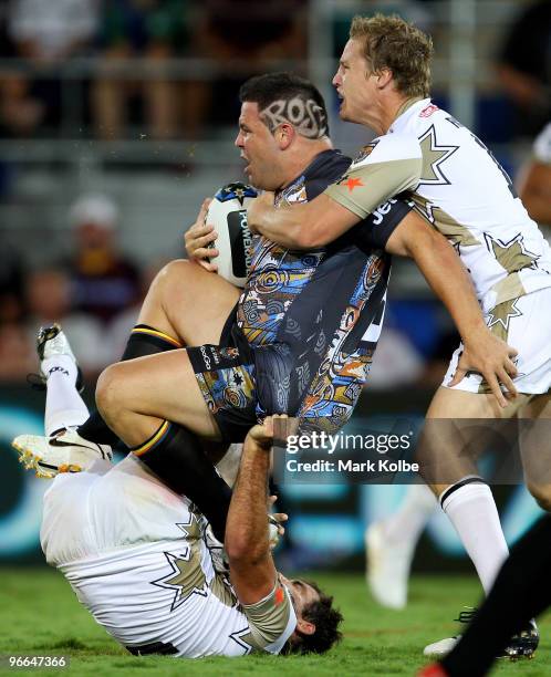 George Rose of the Indigenous All Stars is tackled by Cameron Smith and Brett Finch of the NRL All Stars during the Indigenous All Stars and the NRL...